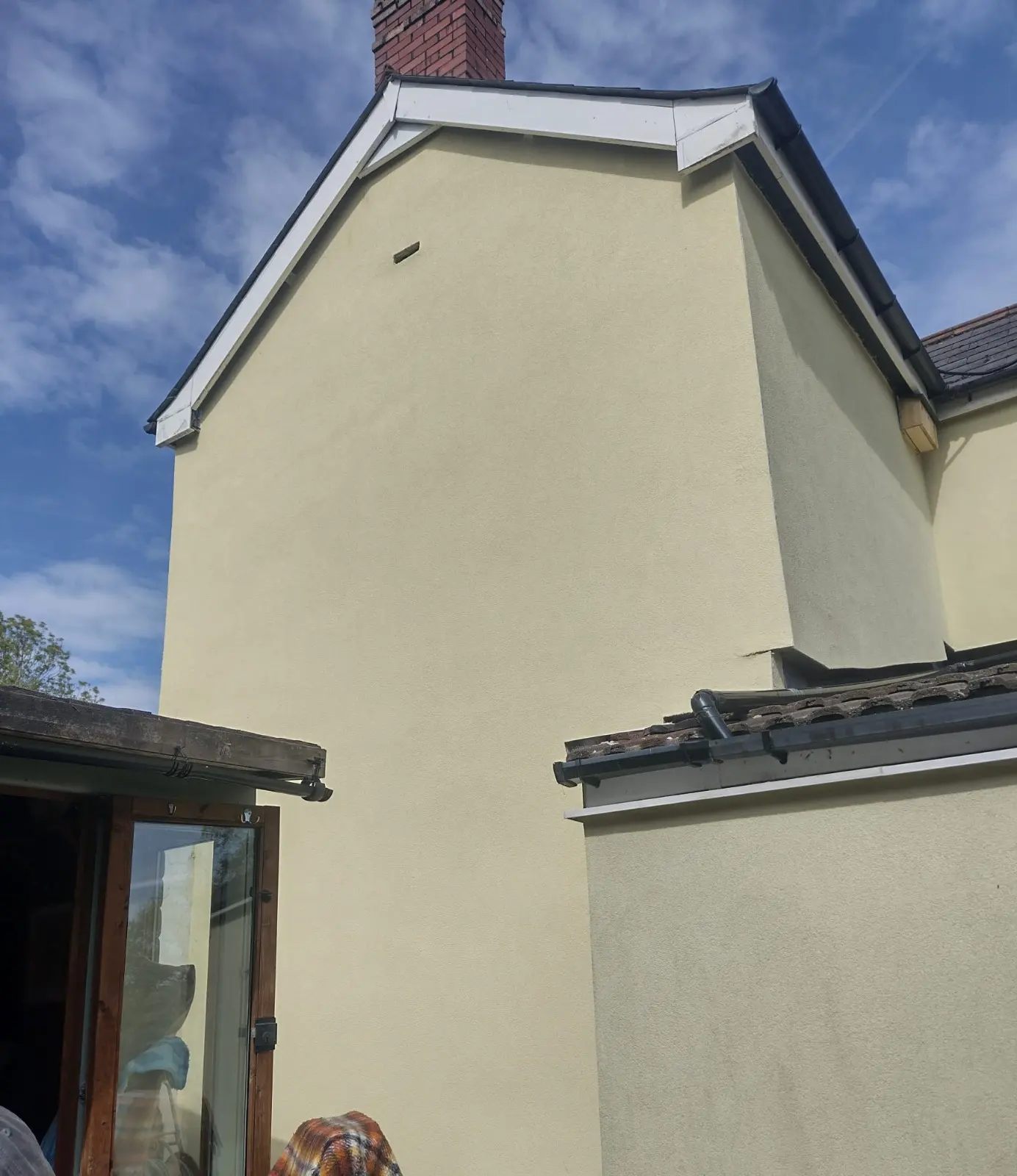 A house that has recently been rendered in a pale yellow colour.