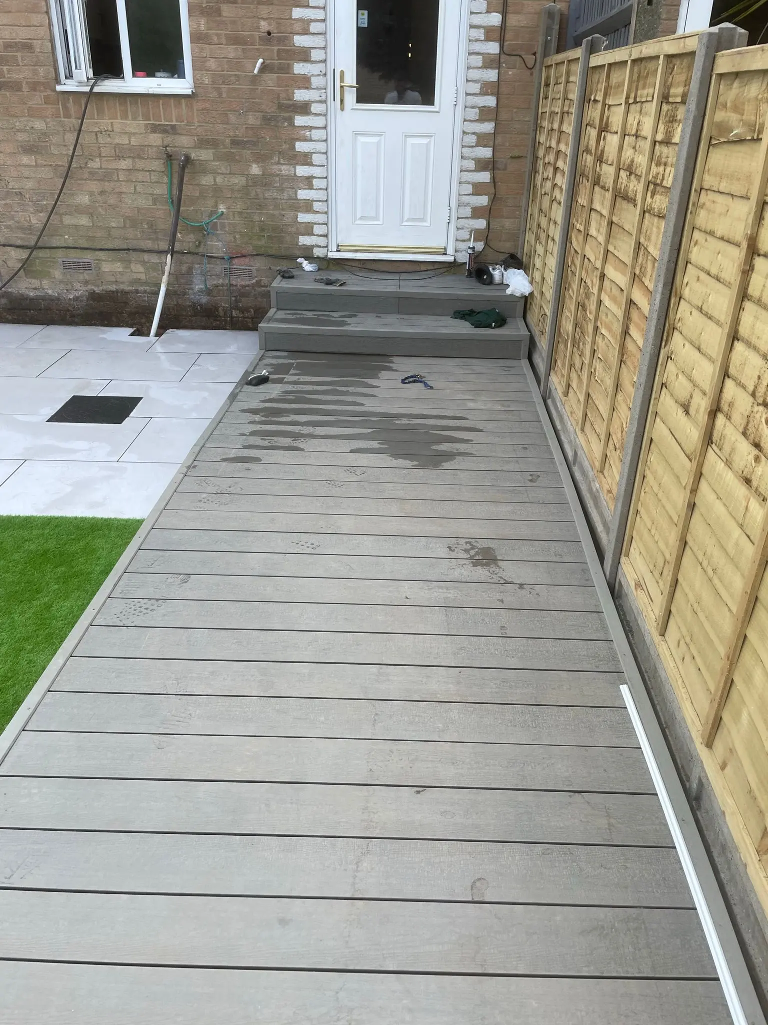 New composite decking installation in a residential garden by Aline Construction