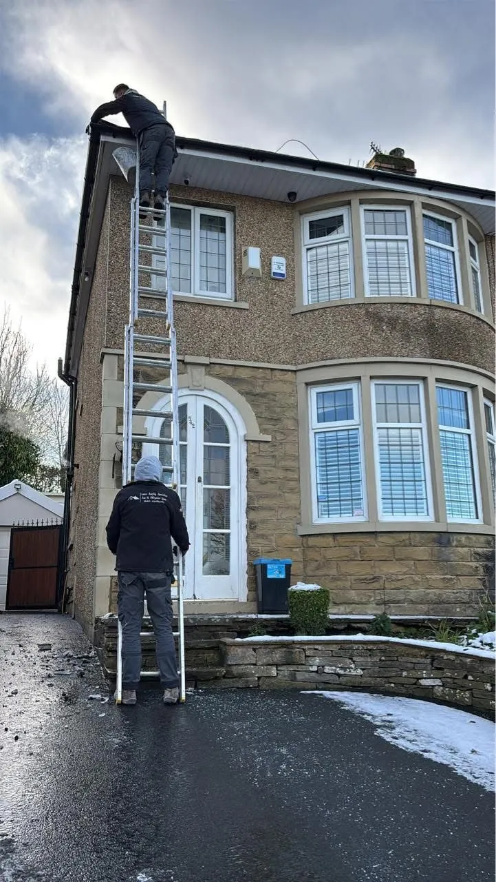Professional roofers from Lancashire Roofing Specialist performing gutter and roofline repairs in Blackburn during winter.
