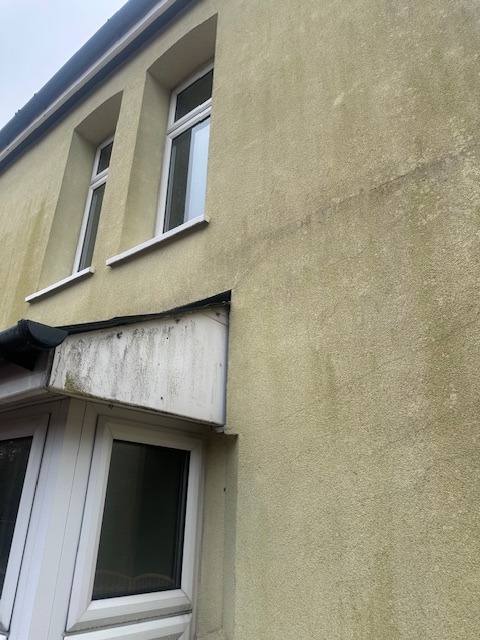 Aged and stained exterior render on a South Wales property.