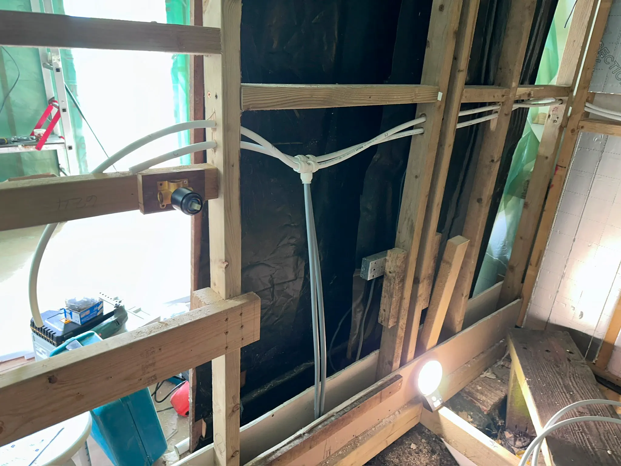 First fix shower plumbing with white pipework and a concealed mixer valve bracket installed in a timber stud wall by JMA Plumbing & Heating.