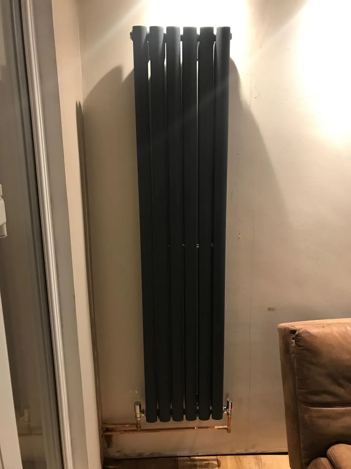 Modern vertical anthracite radiator installation in a Bolton home by MK Plumbing LTD