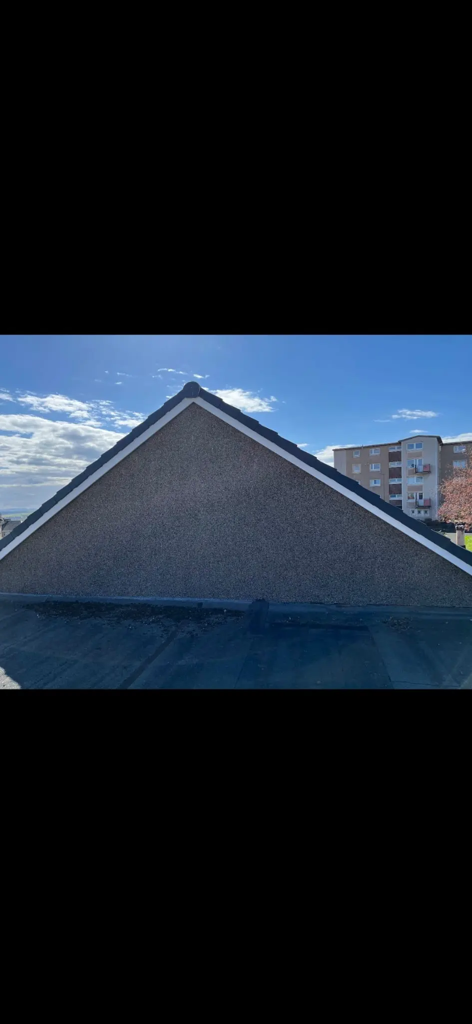 Freshly roughcasted gable end and new white UPVC fascias on a property in Fife