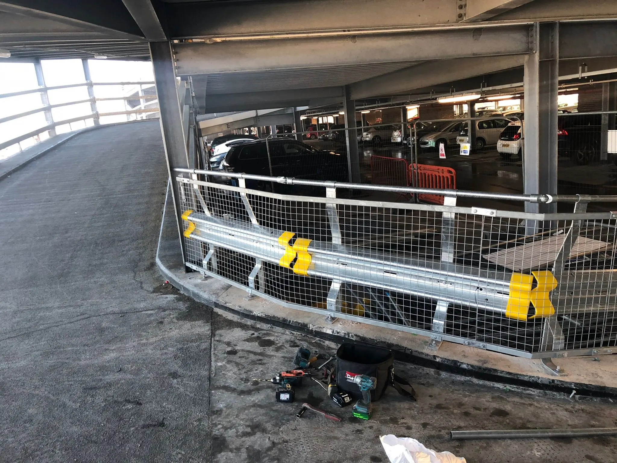 Heavy-duty steel safety barrier and fencing installation in a commercial parking structure