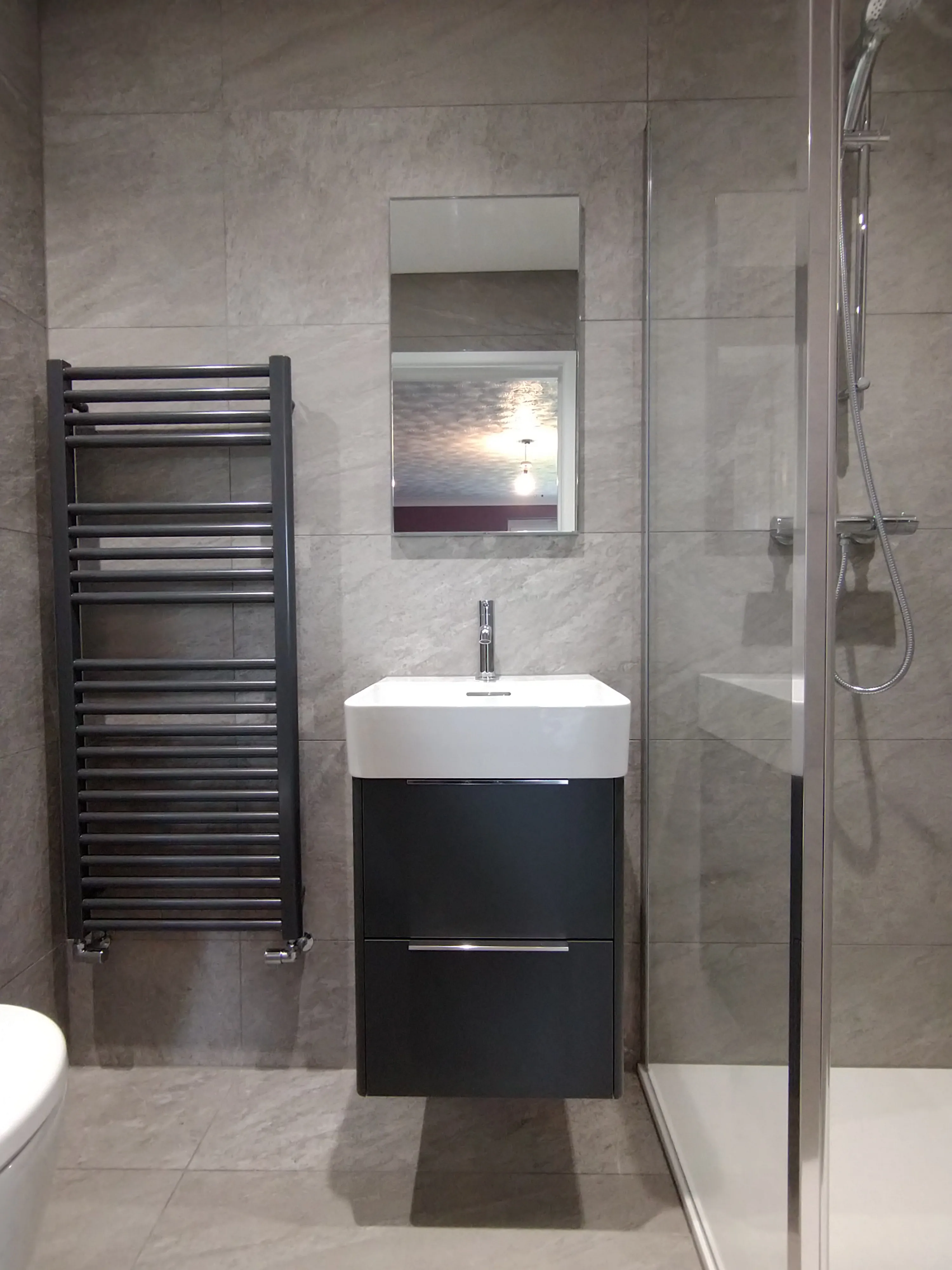 Bespoke luxury bathroom installation in Plymouth featuring a modern walk-in shower and wall-hung vanity by Sands & Vossen.