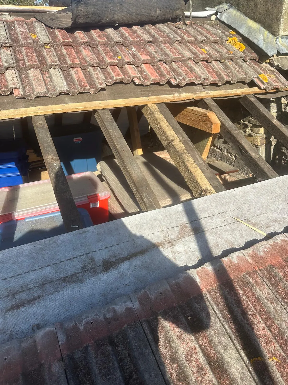 A section of a tiled roof under repair with exposed wooden rafters and new breathable membrane in West Malling.