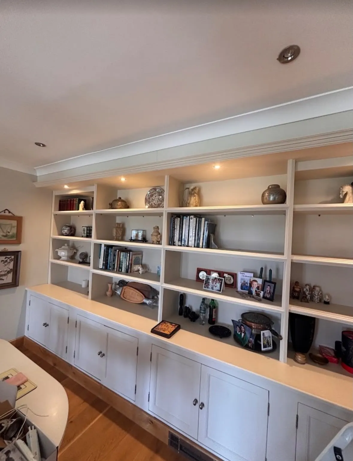 Integrated LED feature lighting installed above custom built-in bookshelves in a home