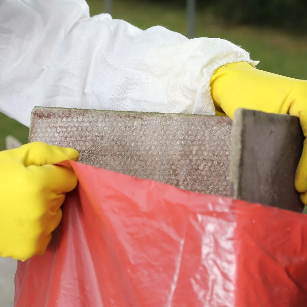 A professional from Stay Safe Environmental safely bagging asbestos waste for disposal in Southampton.