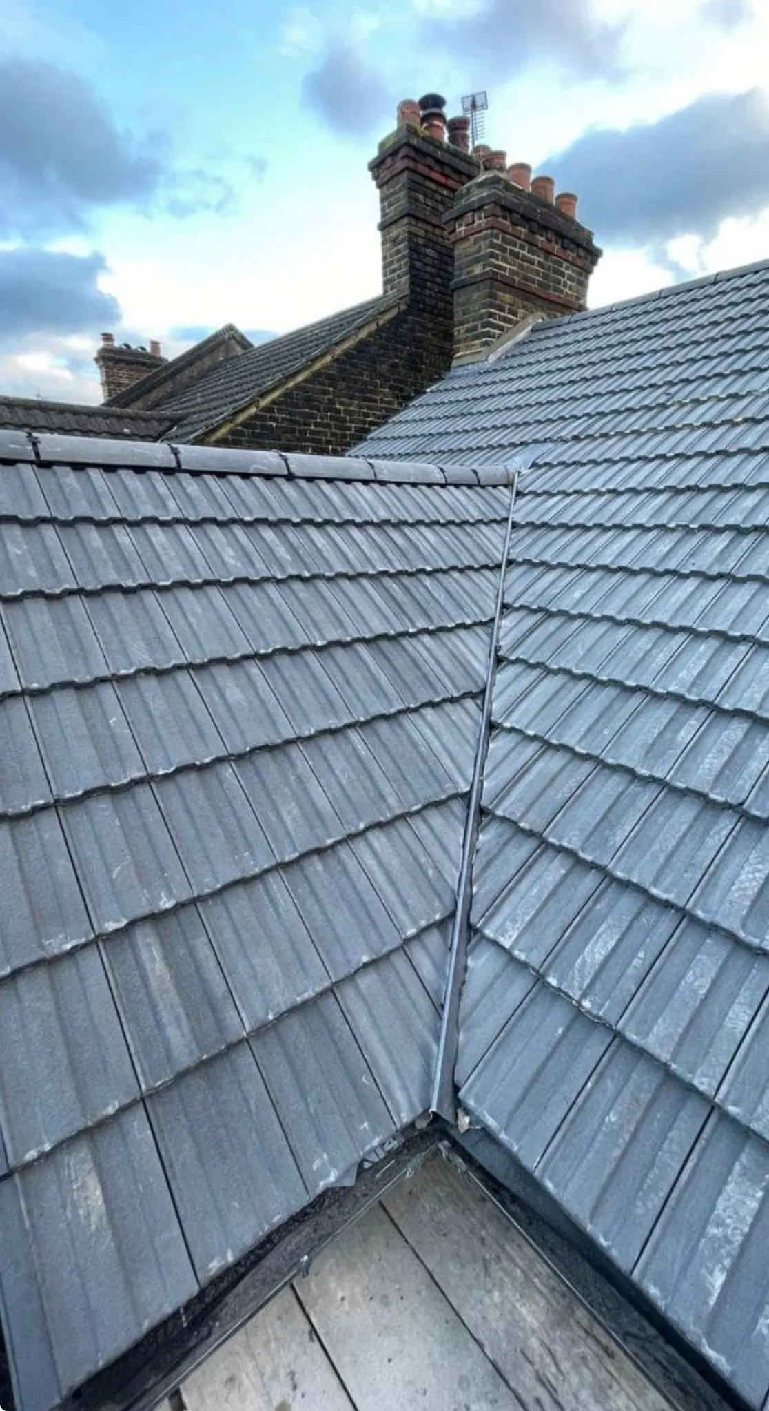 Expertly installed grey interlocking roof tiles and lead valley by Century Roofing and Building