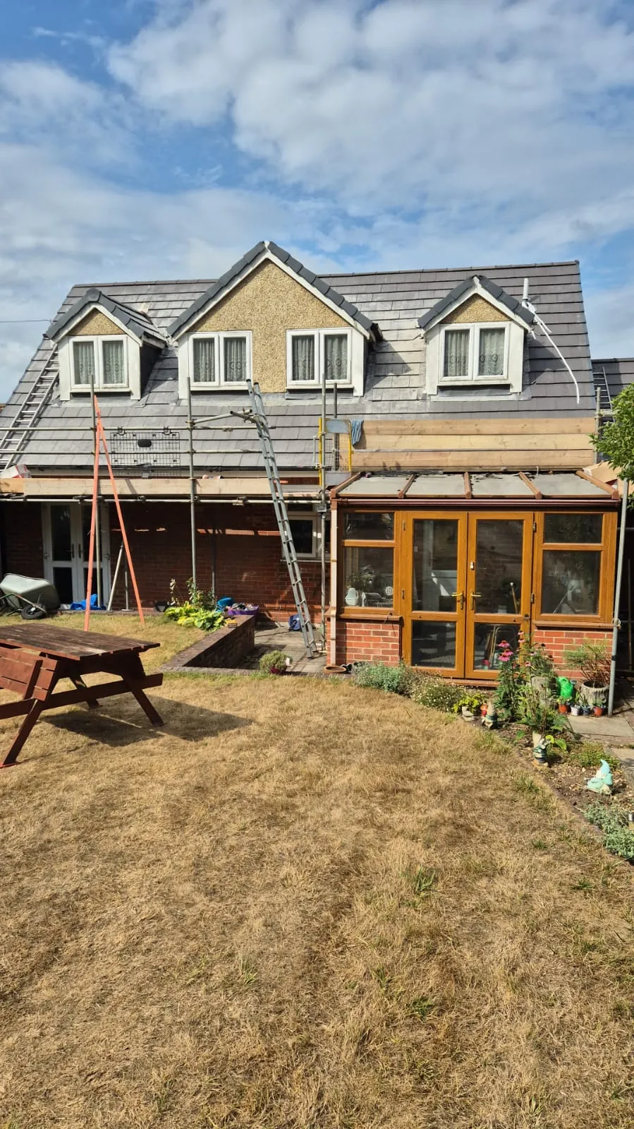 A residential house in Hampshire undergoing pitched roof repairs or replacement with scaffolding installed.