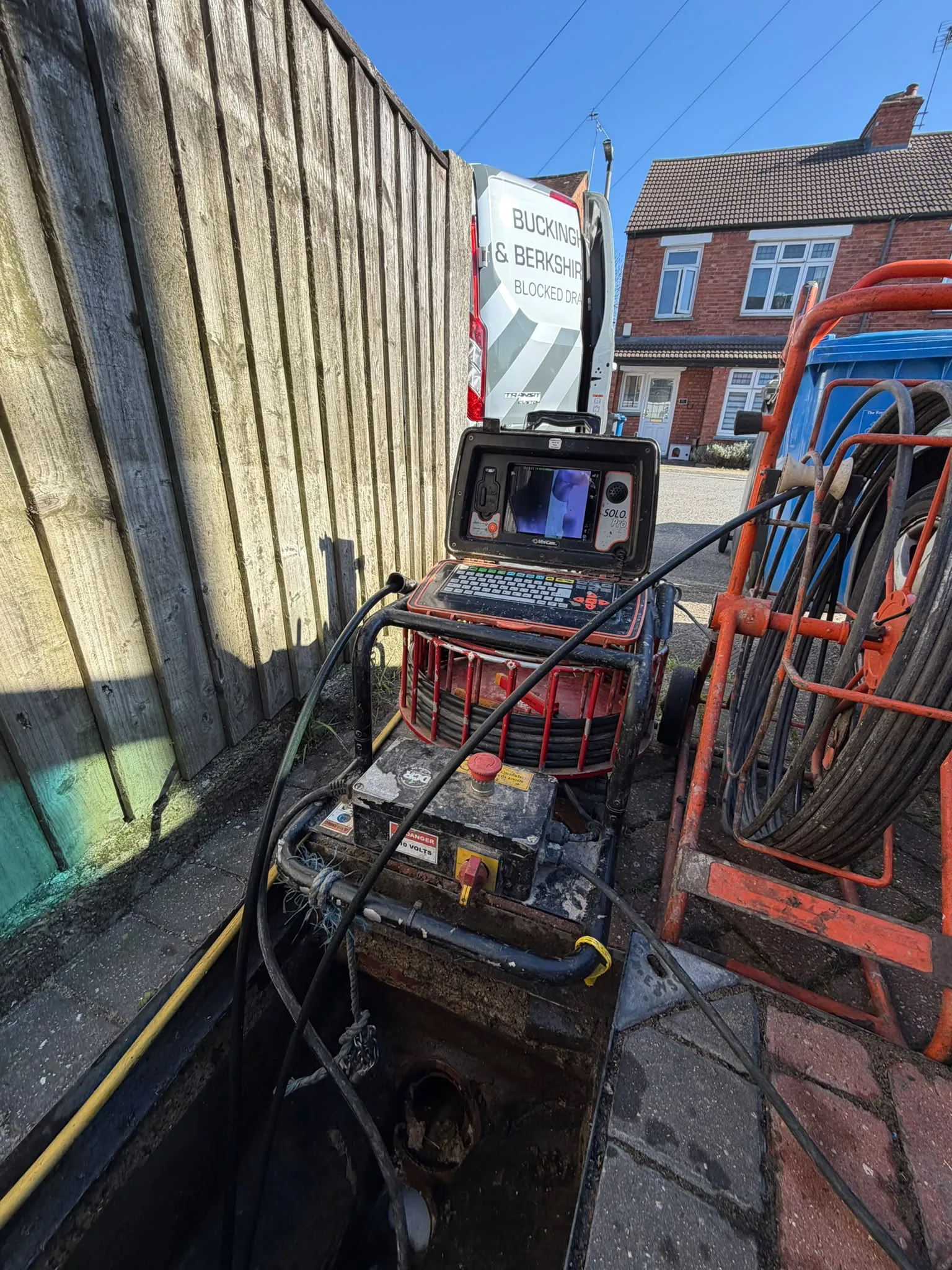 CCTV drain survey camera equipment set up over an open manhole inspection chamber in Slough