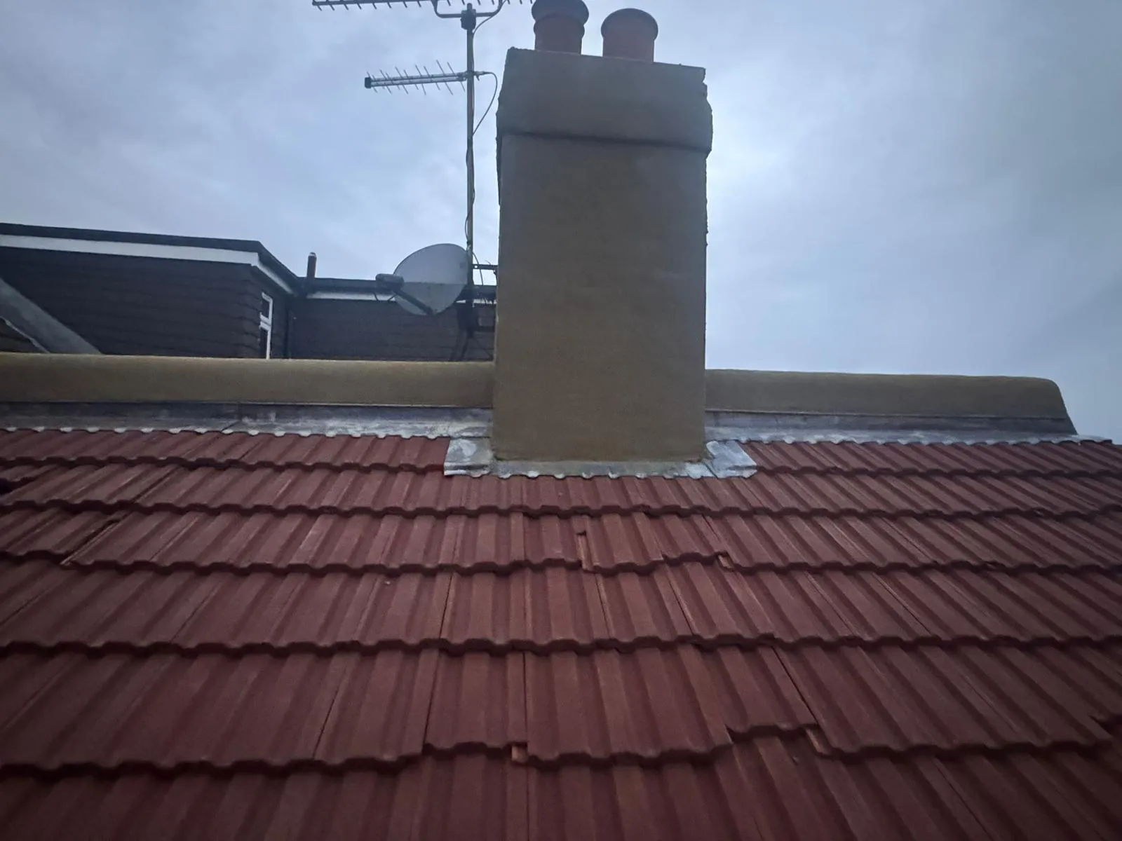Rendered chimney stack and lead flashing repair on a tiled pitched roof in Kent