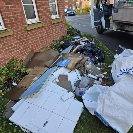 Builders waste and renovation debris piled on grass ready for licensed collection in Birmingham
