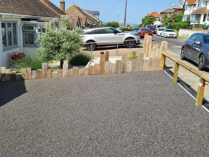 Newly installed dark grey resin-bound driveway with timber edging at a Canterbury home.