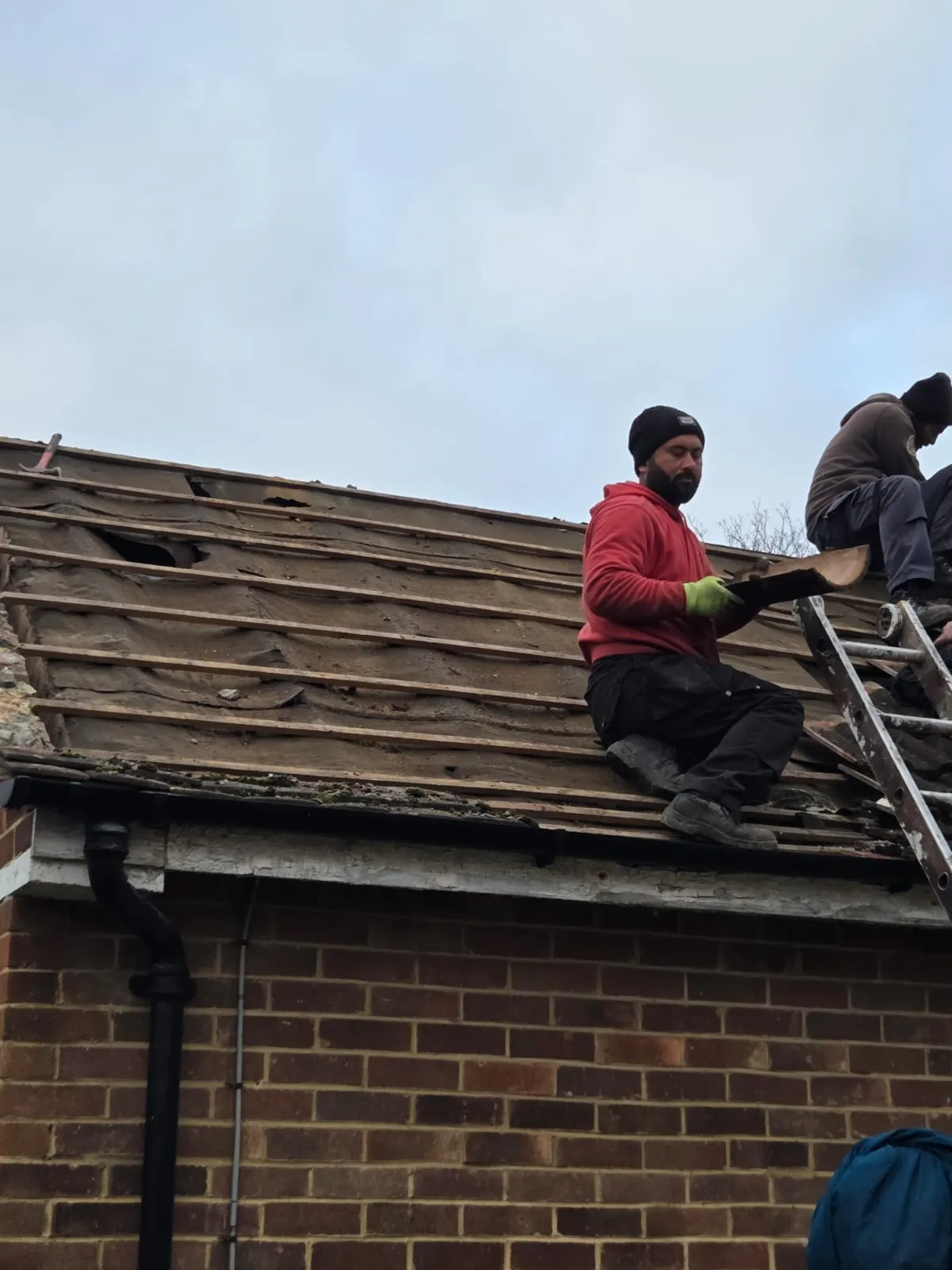 Professional roofers from Cornwall & Plymouth Roofing installing new tiles on a residential pitched roof during a re-roofing project.