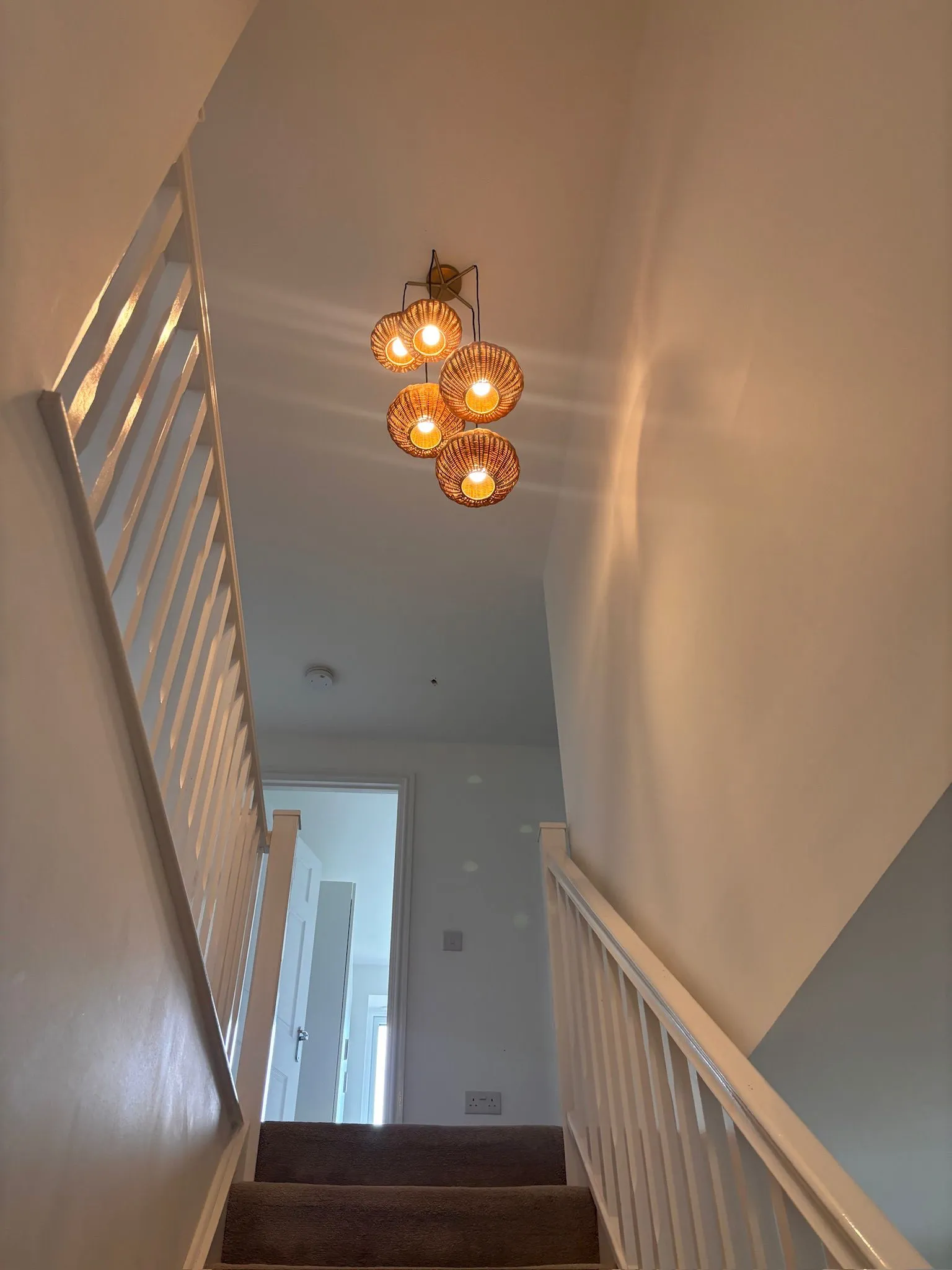 Cluster pendant feature lighting installation above a domestic staircase