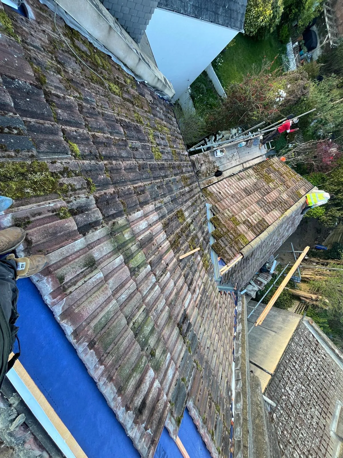 First Choice Roofing Kent team performing a full roof replacement and re-roofing in West Malling, showing blue felt and mossy tiles.