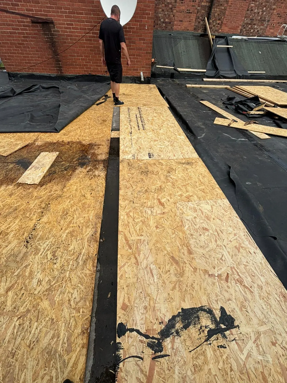 Expert roofer laying OSB decking boards for a new flat roof installation in Ellesmere Port