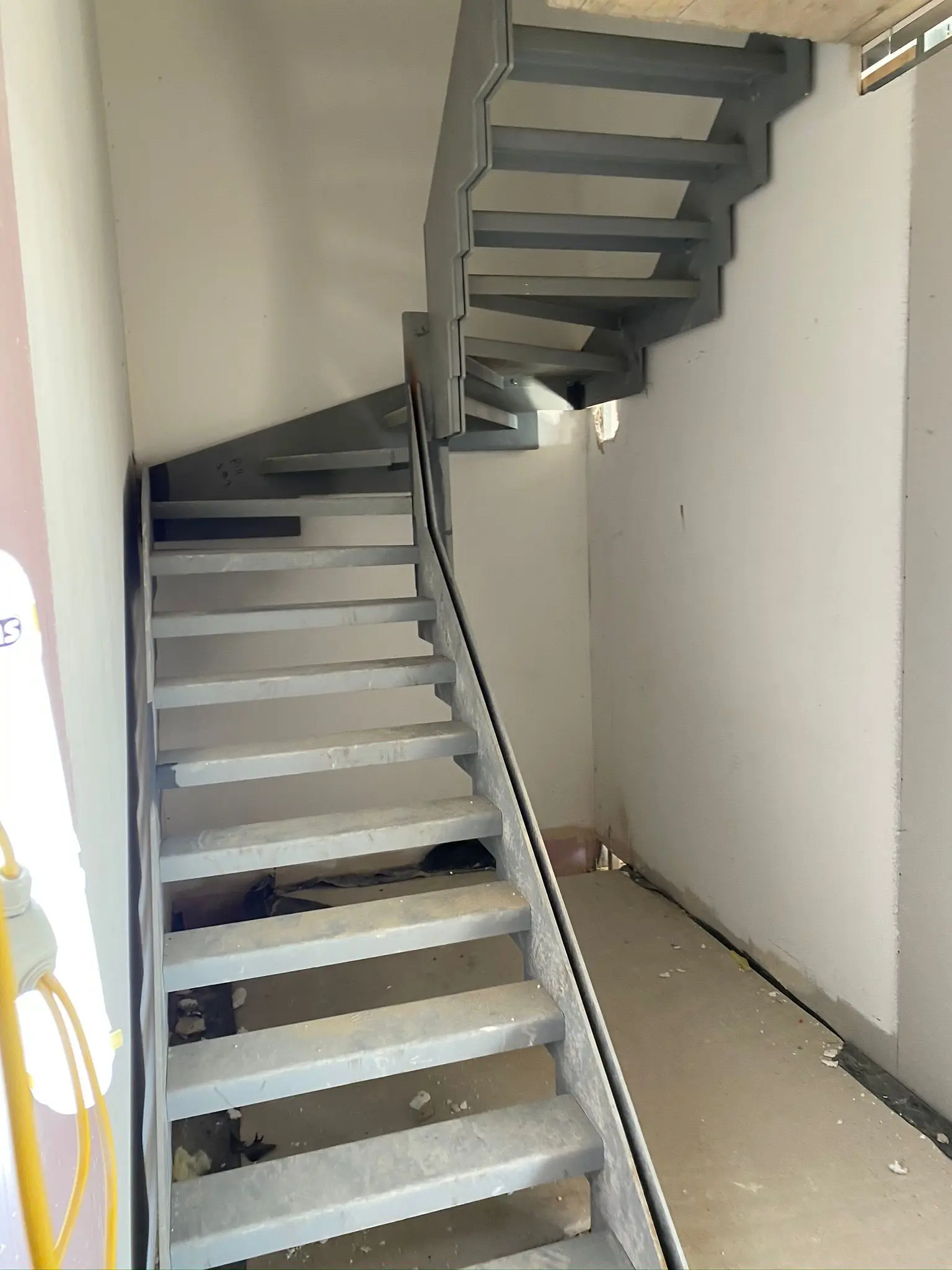 A newly installed steel staircase inside a commercial industrial unit under construction