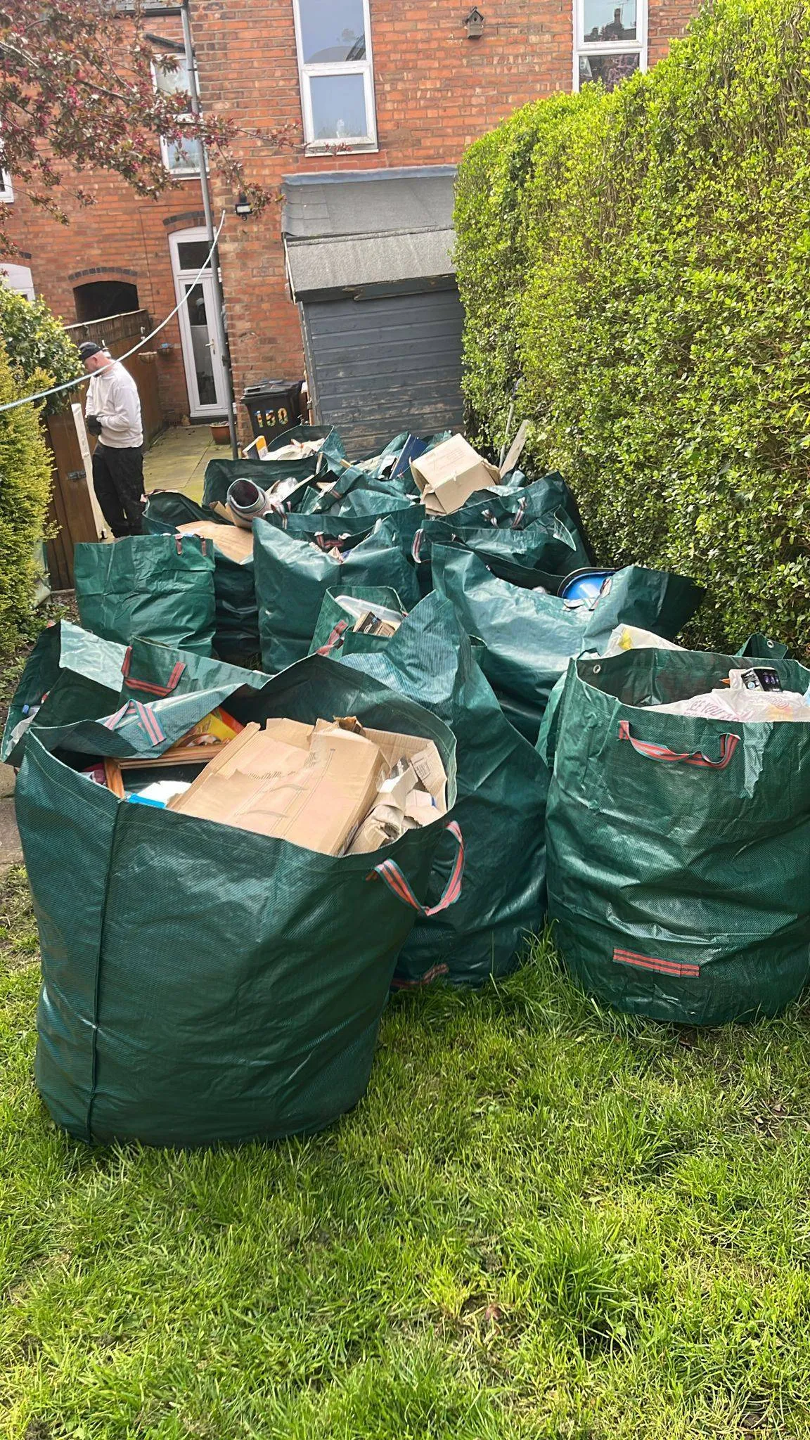 Bagged domestic rubbish and cardboard waste prepared for collection in a Birmingham rear garden