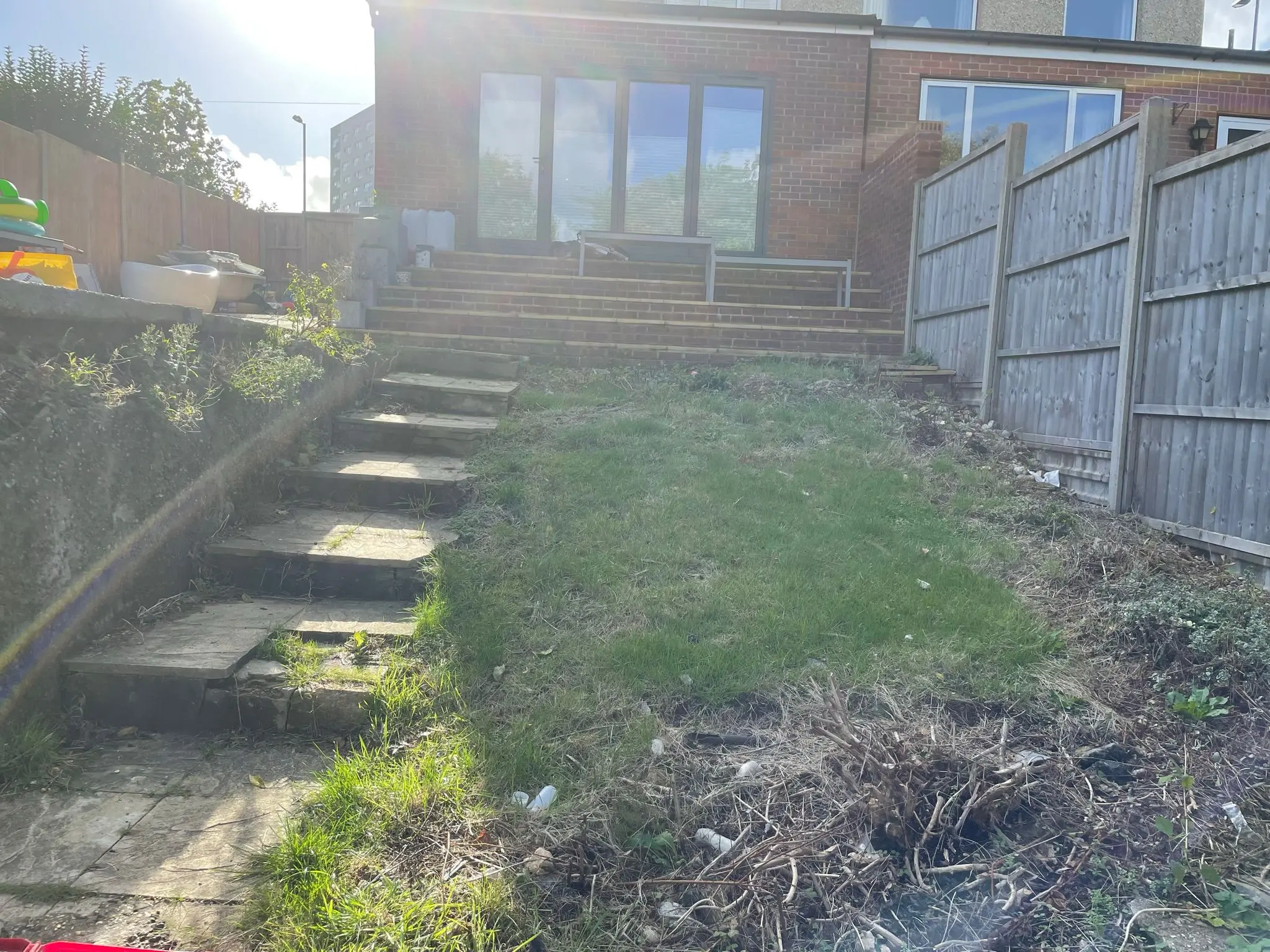 Sloped residential garden before site clearance and hard landscaping by Aline Construction