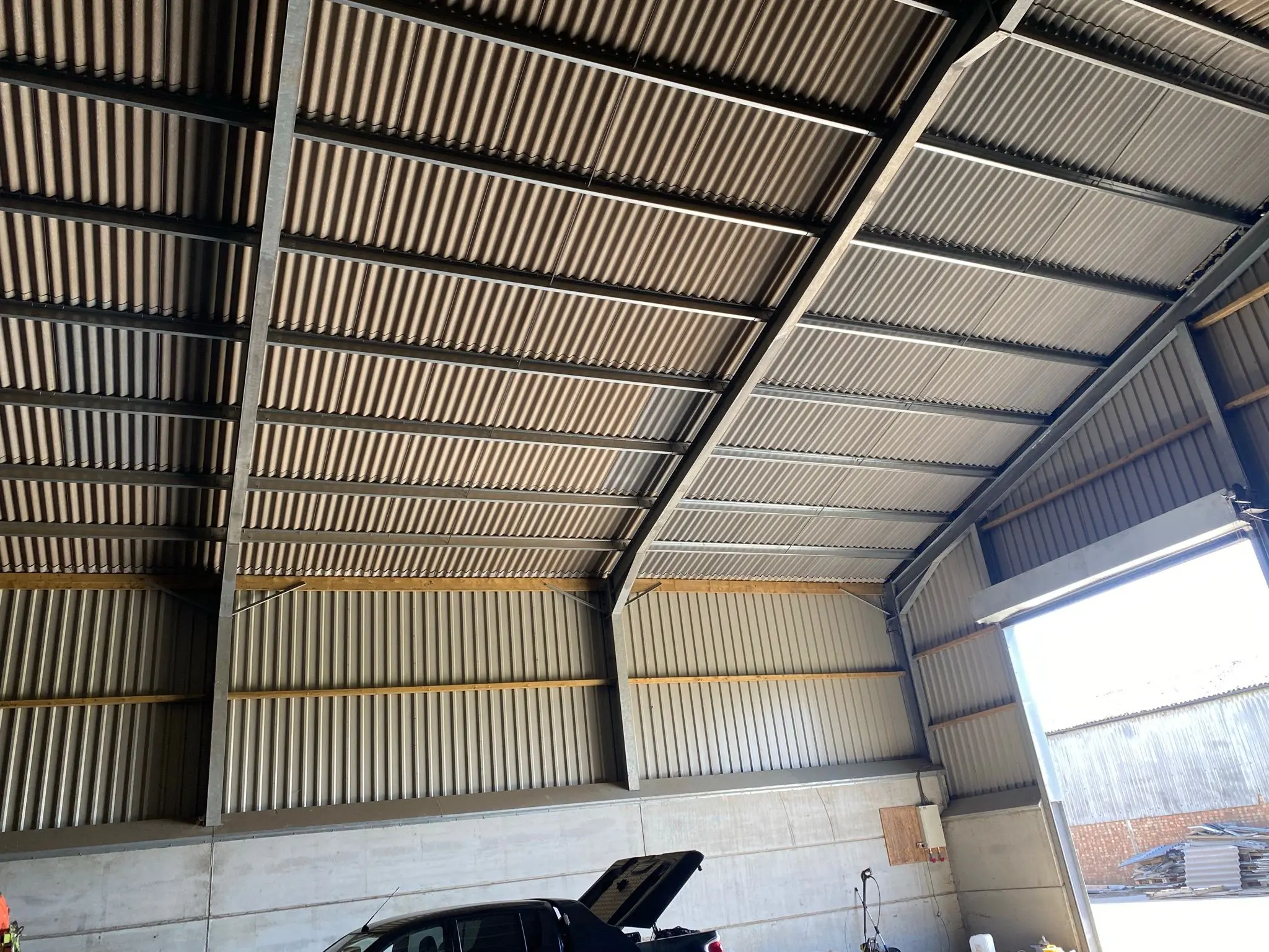 Interior view of a newly constructed steel frame agricultural building and industrial unit showing corrugated roofing and concrete wall panels