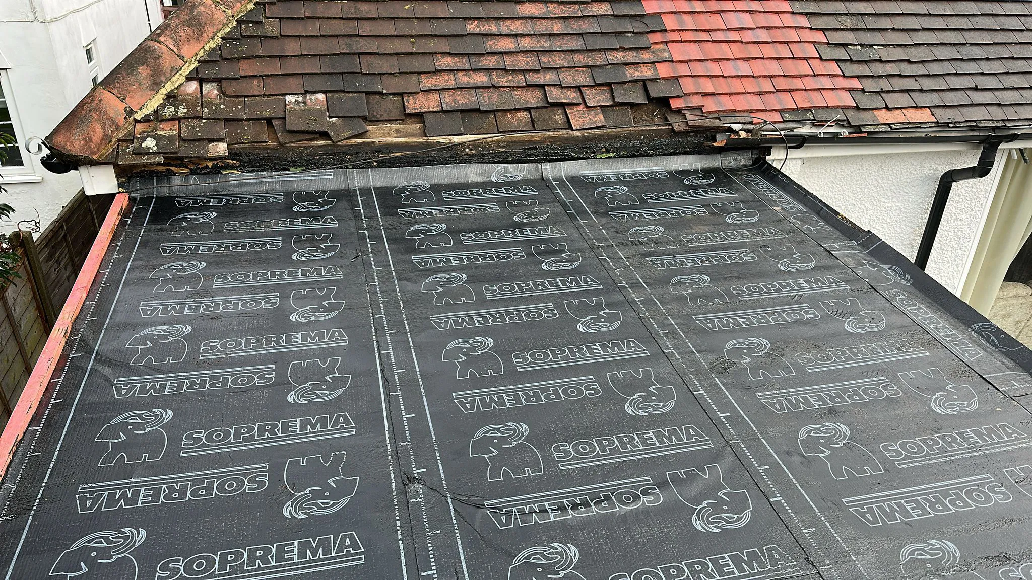 Torch-on felt flat roof membrane installation on an extension roof