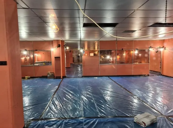 Internal room preparation for safe asbestos removal showing protective floor covering and temporary lighting
