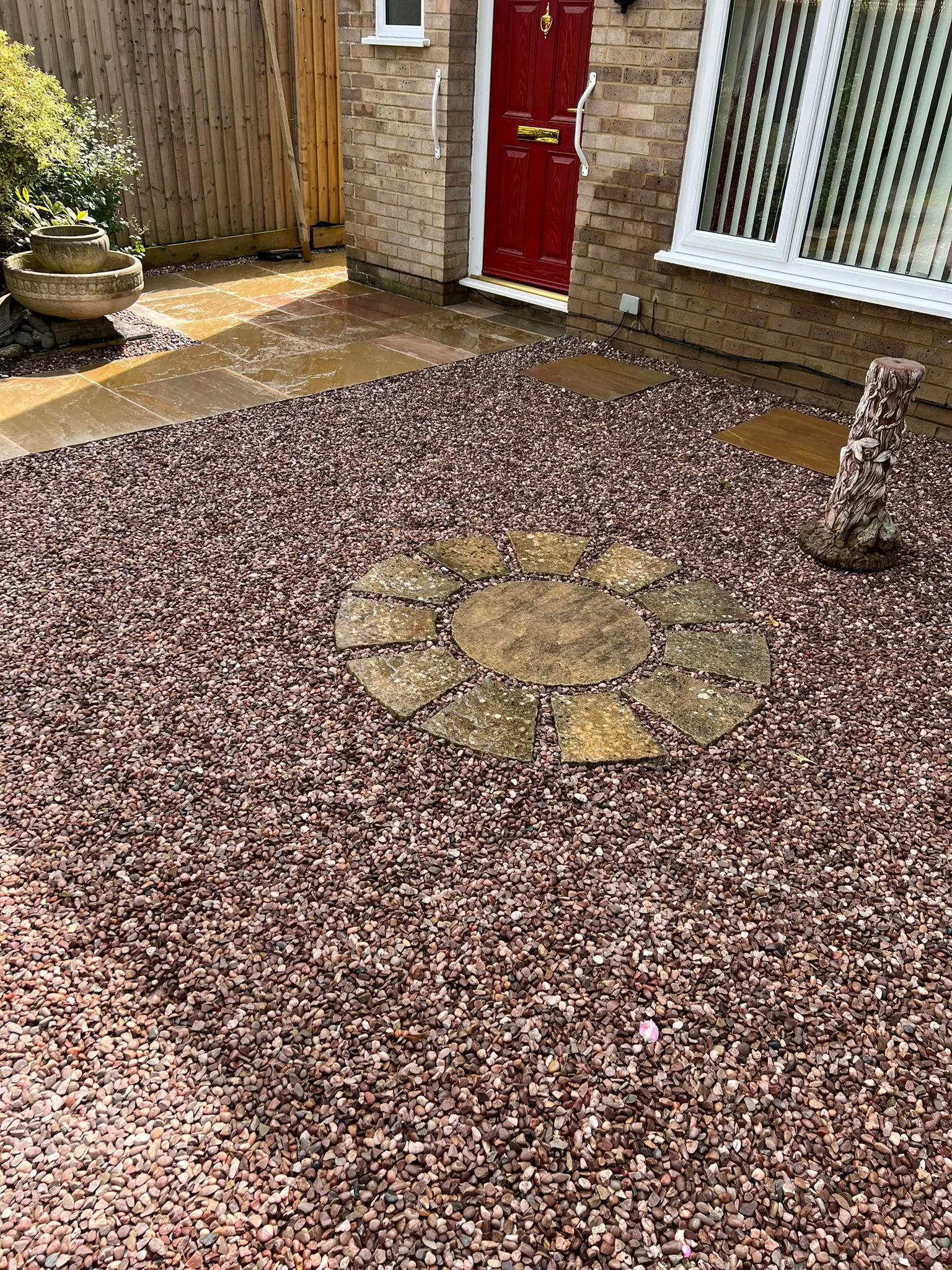 Landscaped front garden with red gravel and natural stone paving slabs