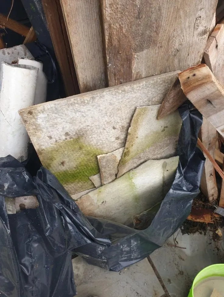 Broken asbestos cement sheets being bagged for safe disposal in Southampton