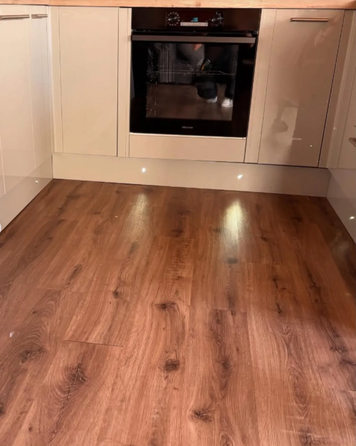 Hardwired electric oven and integrated LED kickboard lighting installed in a modern kitchen
